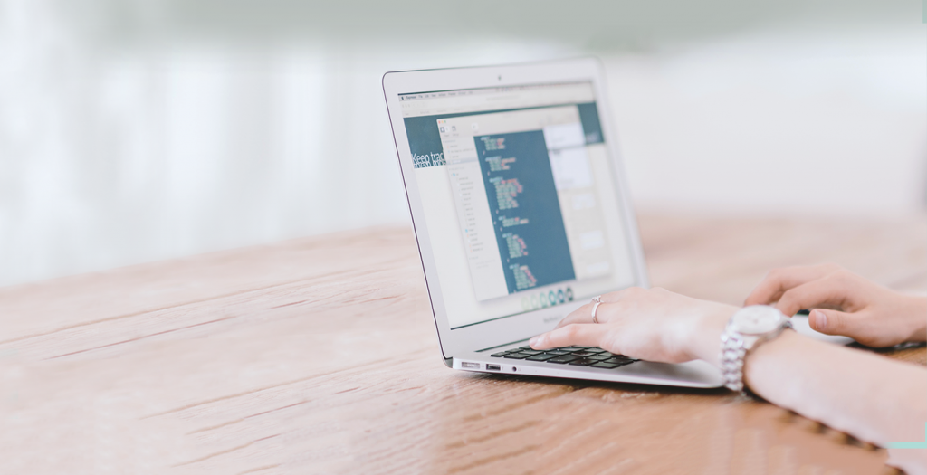 open laptop on a desk with hands typing 